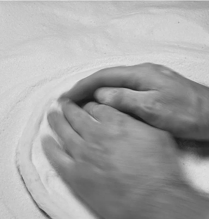 Étalage de la pâte à pizza avec un zoom sur les mains